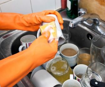 washing dirty mugs in sink