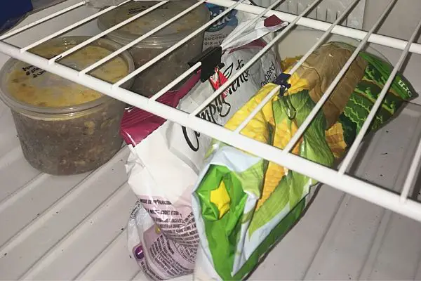 frozen veggies hanging from freezer shelf with binder clip