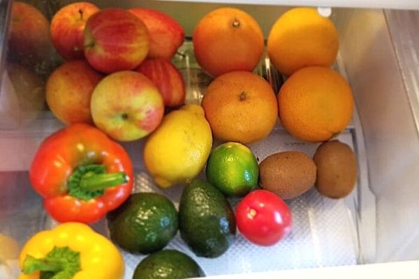 open fridge drawer filled with fruit and transparent refrigerator drawer liner