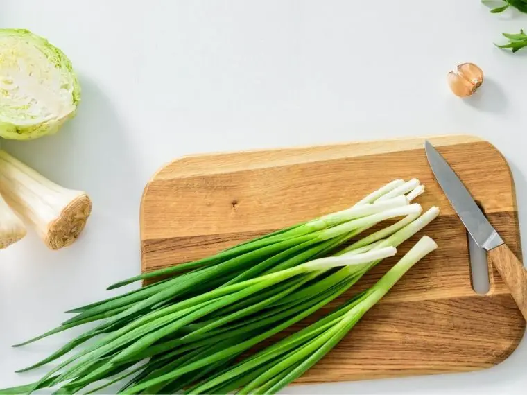 how to store green onions. scallions on wooden cutting board