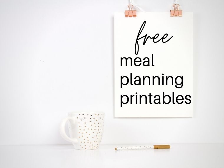 clipboard that says free meal planning printables hanging above mug and pen