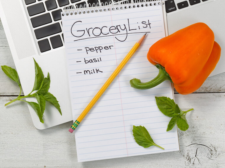 grocery list for Amazon notepad, pencil, bell pepper, leaves, laptop flatlay