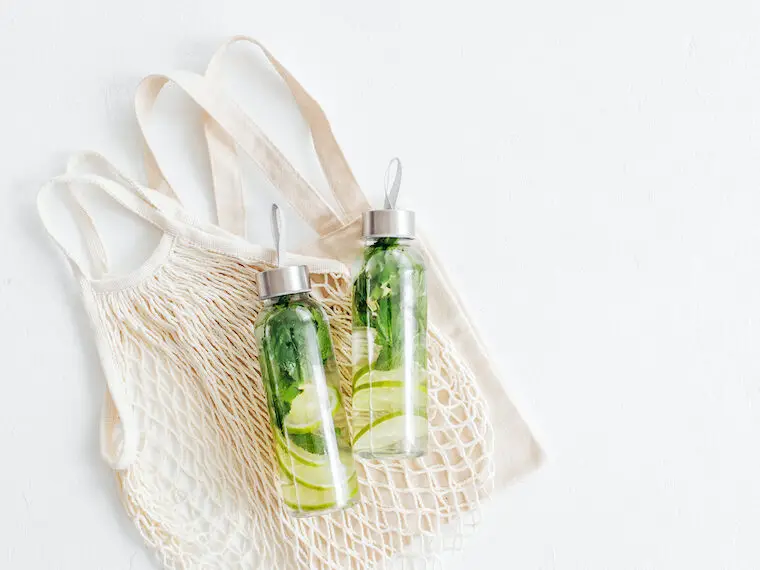 minimalist aesthetic water bottles with fresh lime and mint infused water and reusable grocery bags