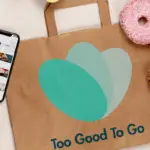 Too Good To Go Review image of phone with app on top of brown bag with donut and bread