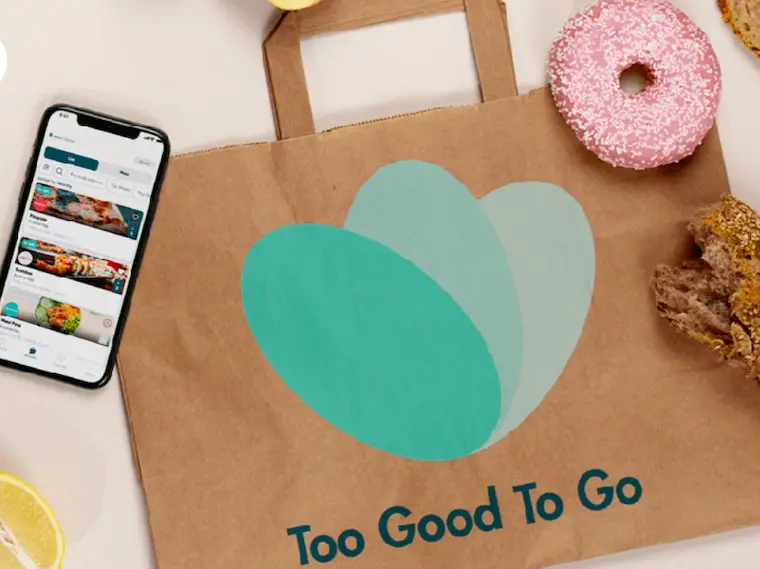 Too Good To Go Review image of phone with app on top of brown bag with donut and bread